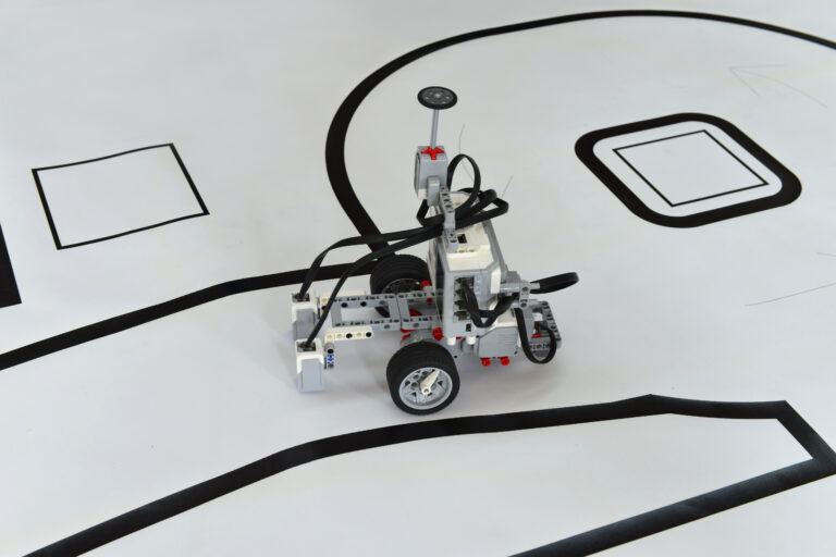 Programmable robot with wheels driving on paper road. Toy robotic car with obstacle avoidance and line follow ability.